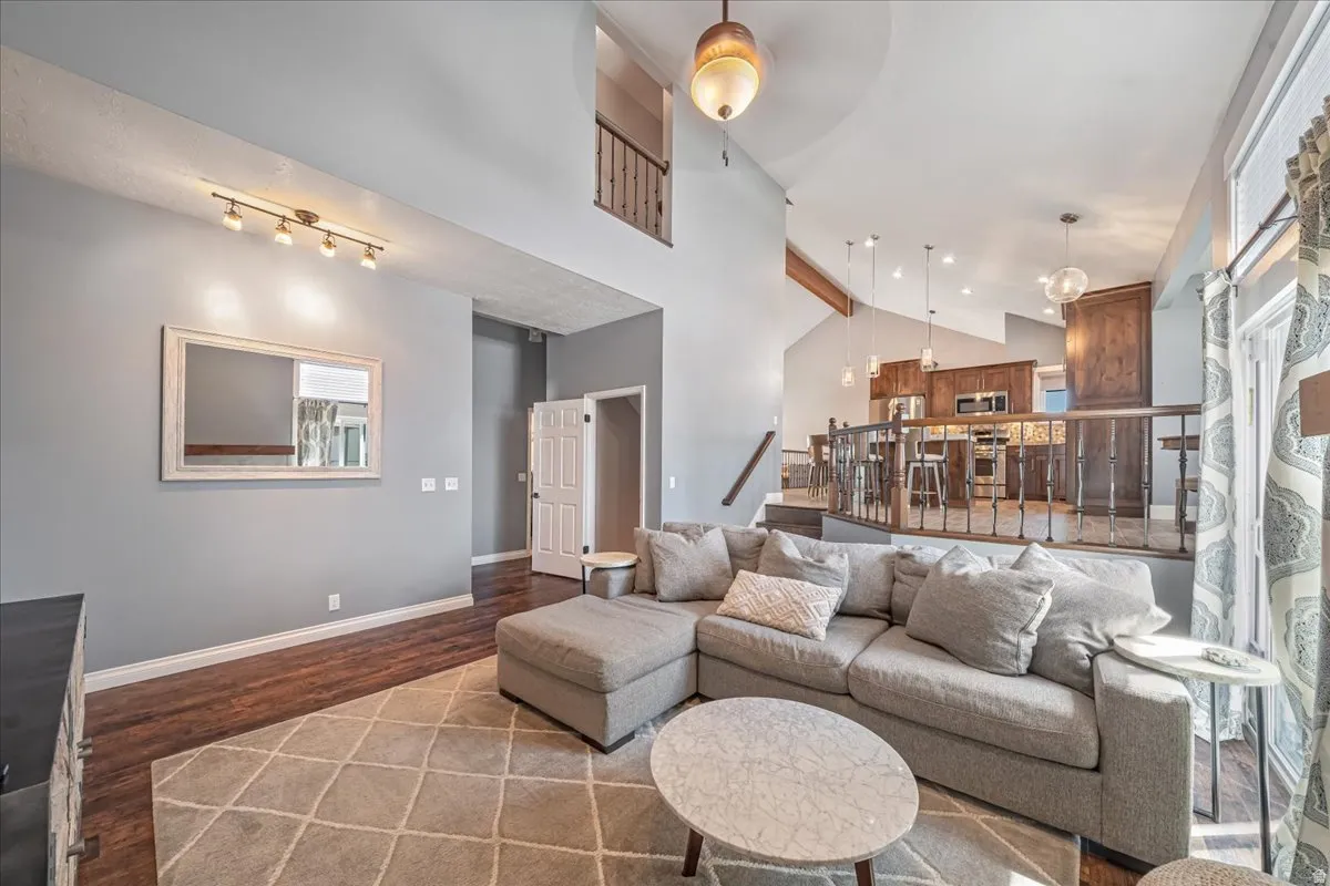 Living room featuring wood finished floors, lofted ceiling, and ceiling fan
