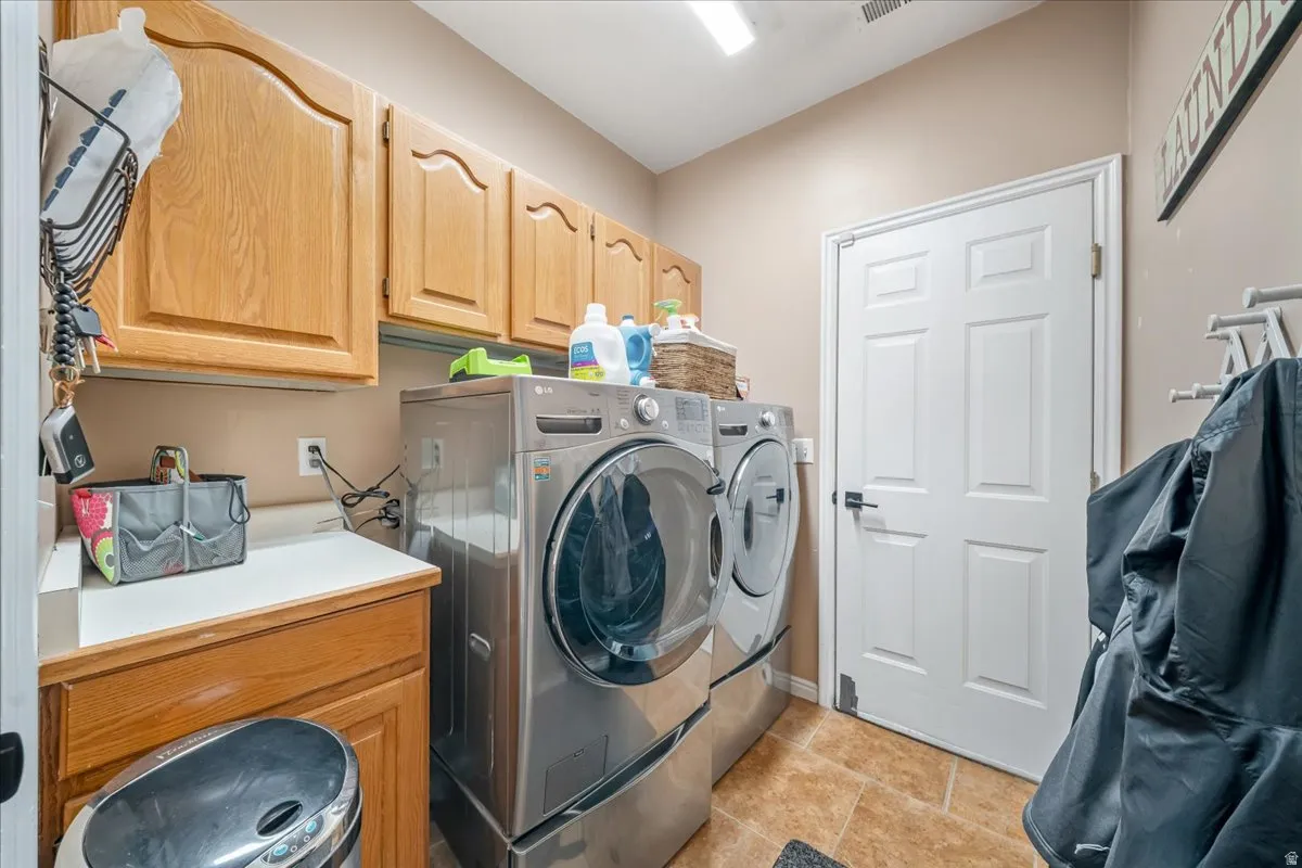 Laundry room with washer and clothes dryer and cabinet space