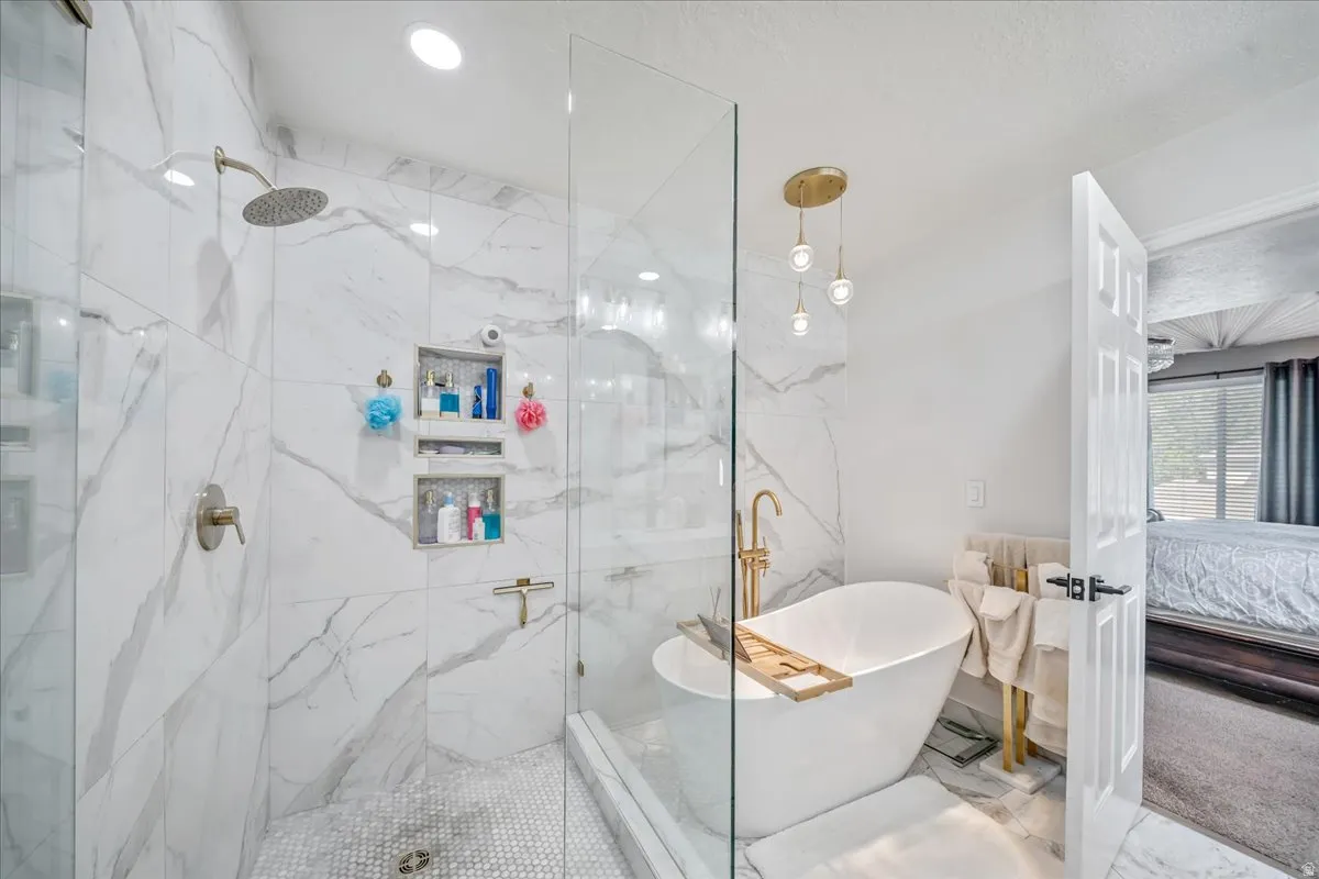 Ensuite bathroom with a freestanding tub and a marble finish shower