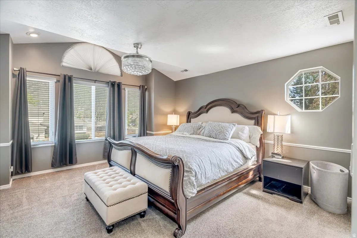 Bedroom with multiple windows and light colored carpet