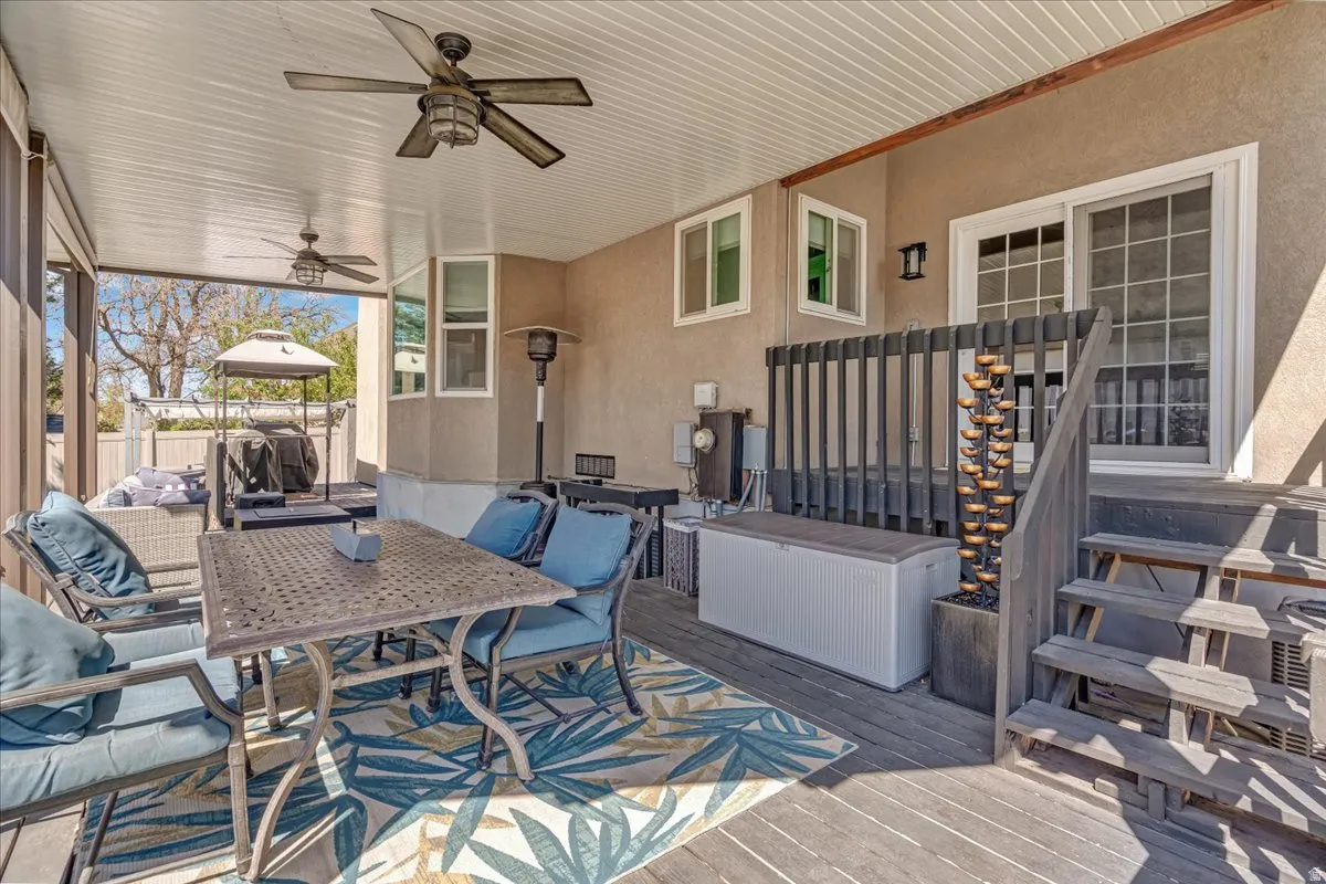 Wooden deck featuring ceiling fan and outdoor dining space