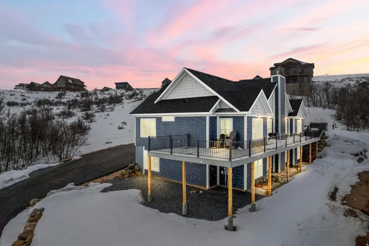 Snow covered property featuring a wooden deck and a chimney