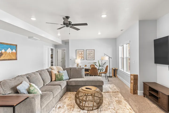 Living area featuring ceiling fan, light colored carpet, and recessed lighting