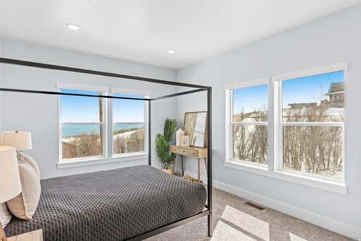 Bedroom featuring light carpet and a water view