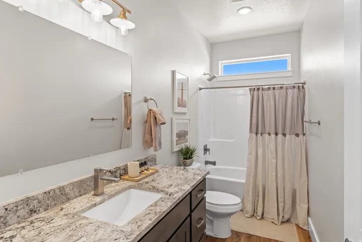 Full bath with vanity, shower / bath combination with curtain, a textured ceiling, and dark wood-style flooring