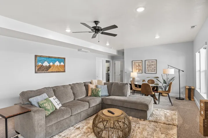 Living room with carpet flooring, a ceiling fan, plenty of natural light, and recessed lighting