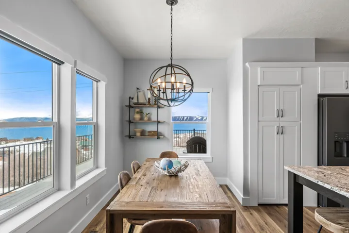 Dining area with a water view, hanging lights, and light wood-style floors
