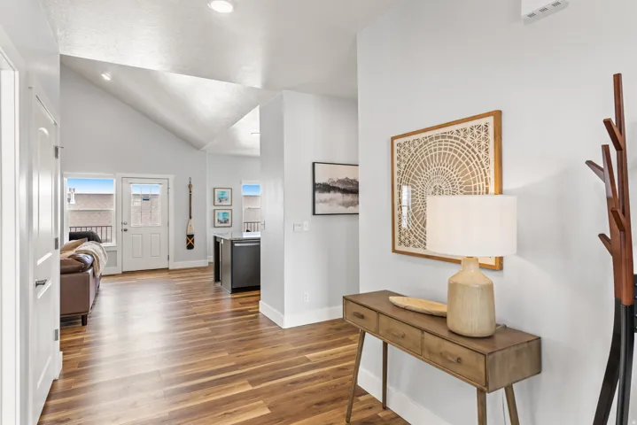 Hall with vaulted ceiling and dark wood-style flooring