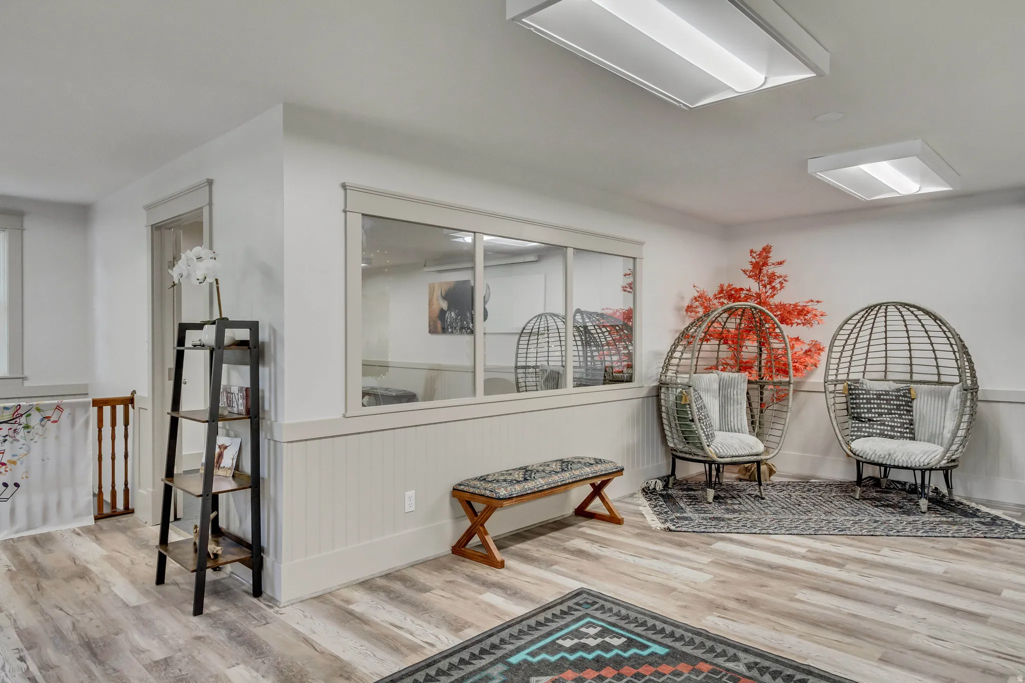 Living area with wainscoting and light wood-type flooring