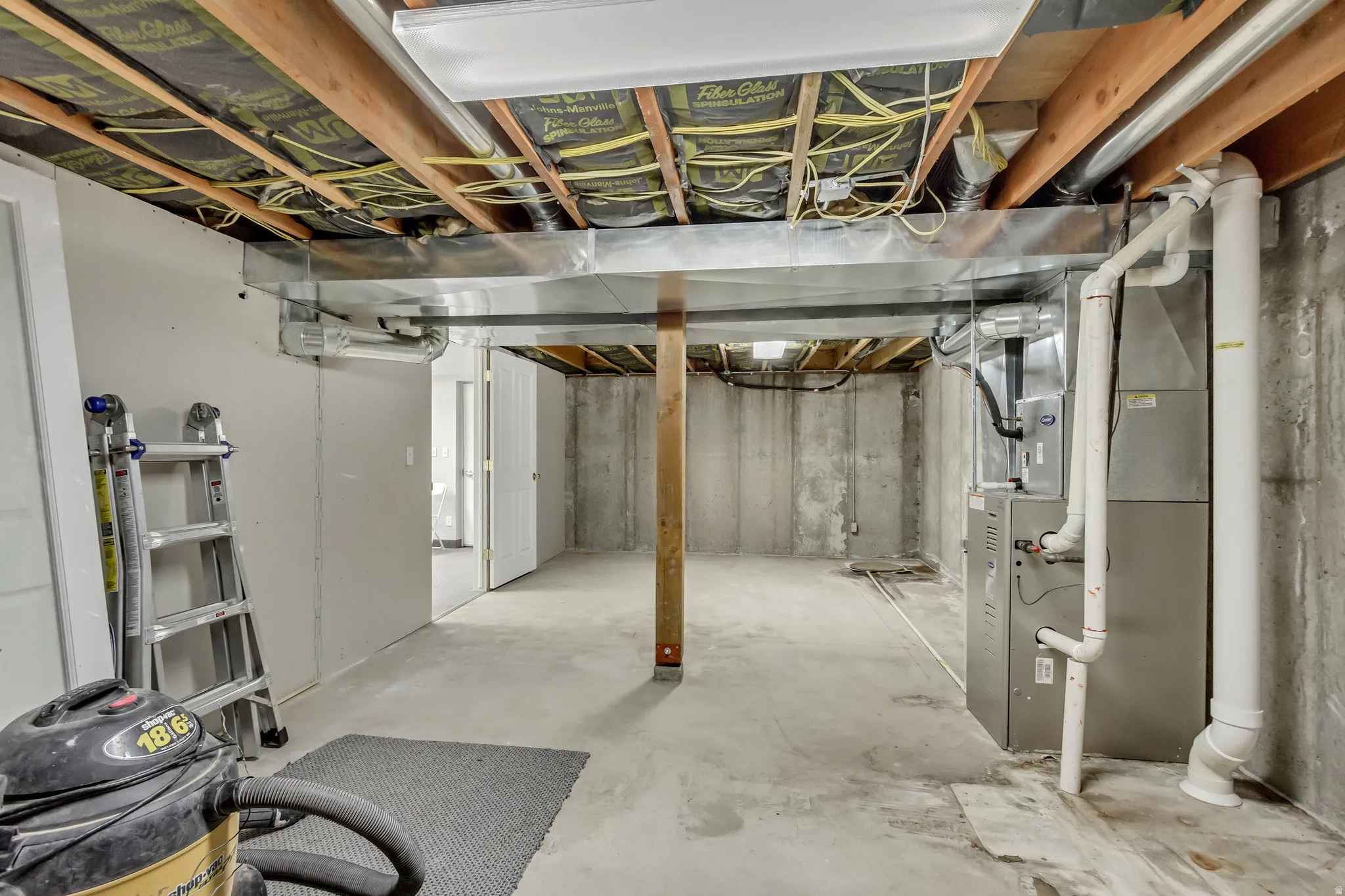Unfinished below grade area featuring heating unit