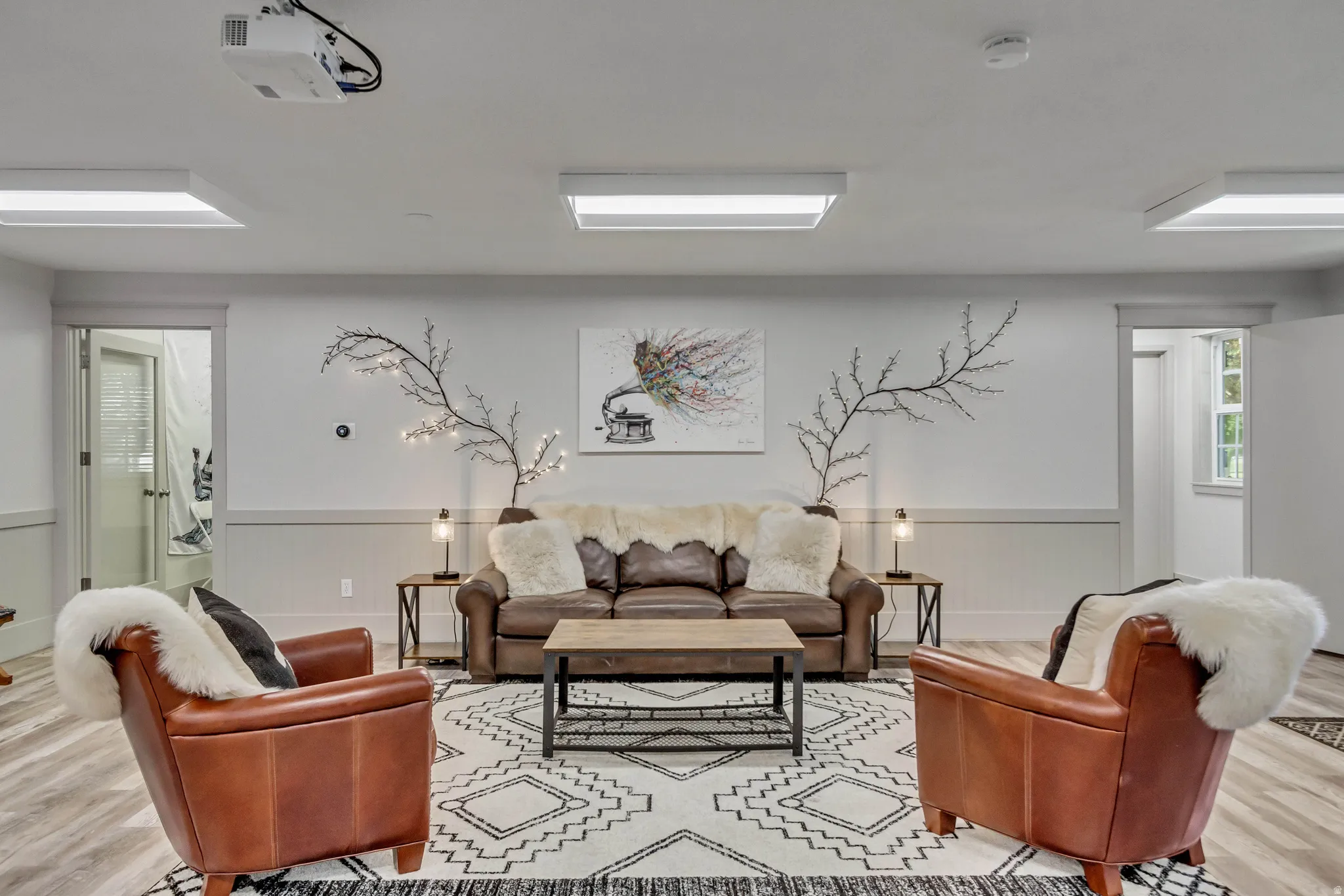 Living area featuring light wood finished floors and a wainscoted wall