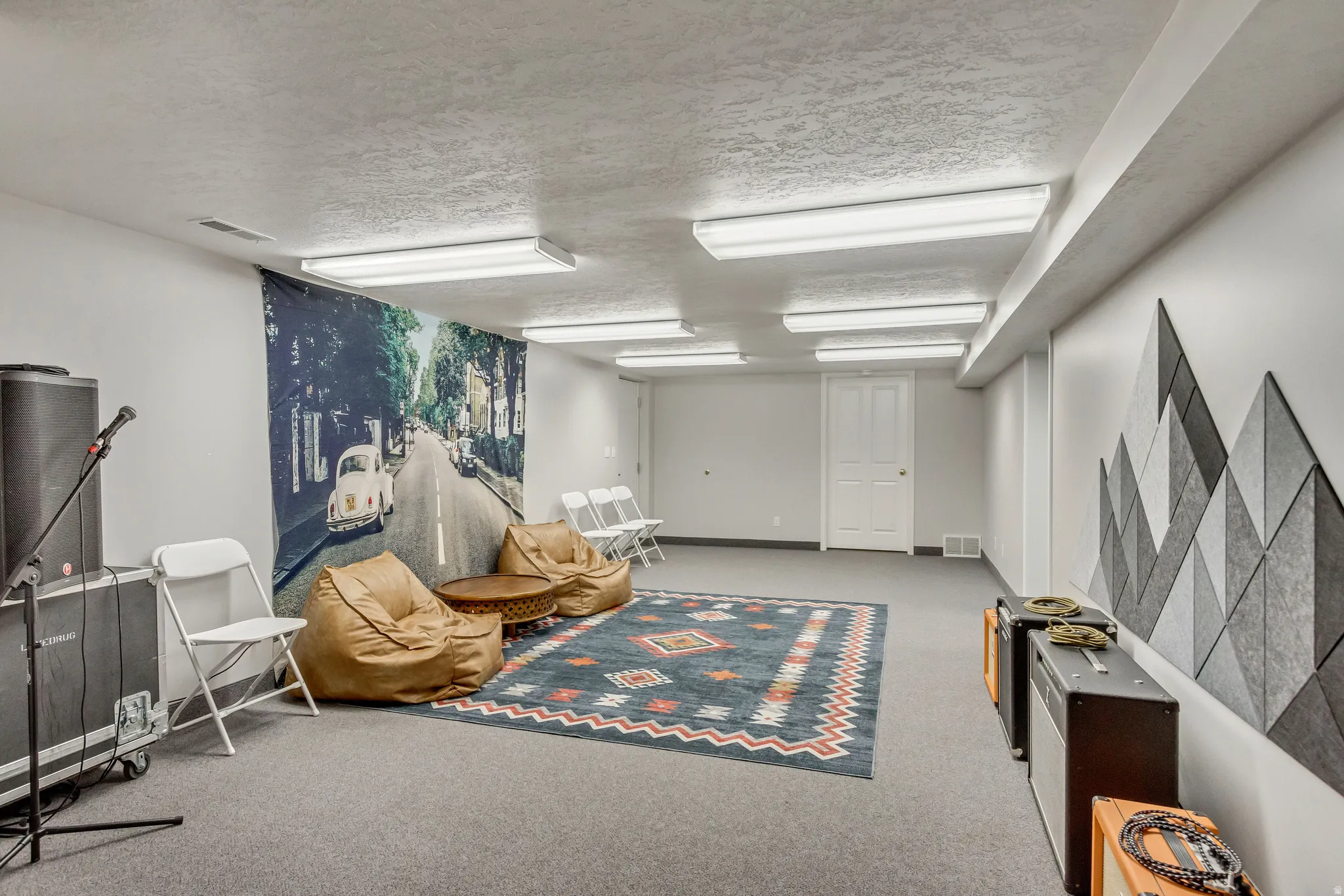 Finished below grade area with light carpet and a textured ceiling