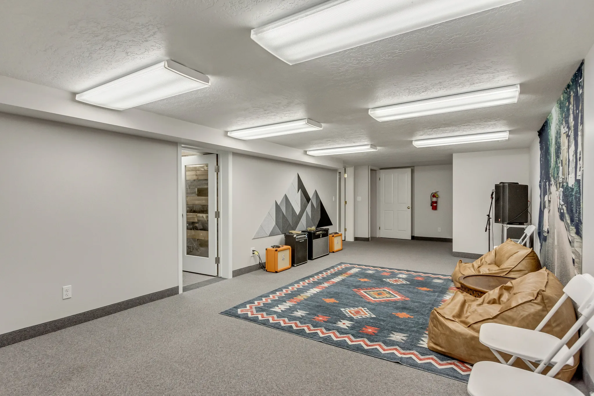 Finished below grade area featuring a textured ceiling and light colored carpet