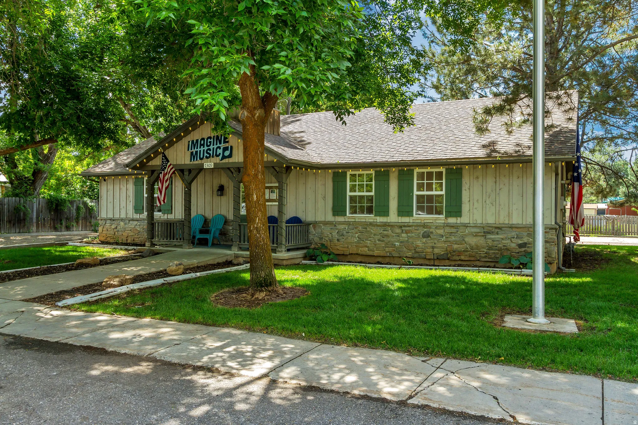 View of front of home featuring stone siding, board and batten siding, a porch, and a shingled roof