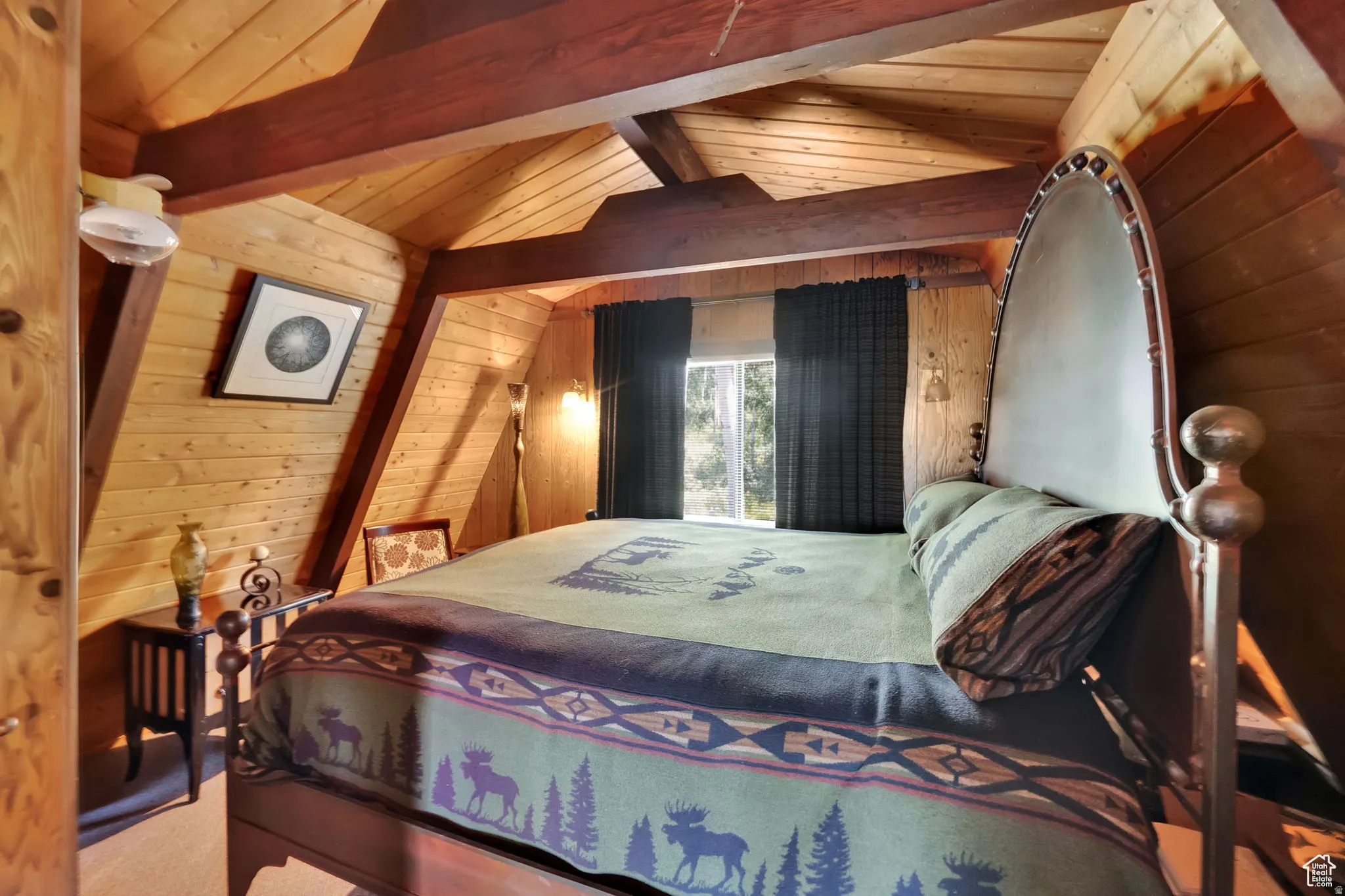 Bedroom with wooden walls and a wooden ceiling with exposed beams