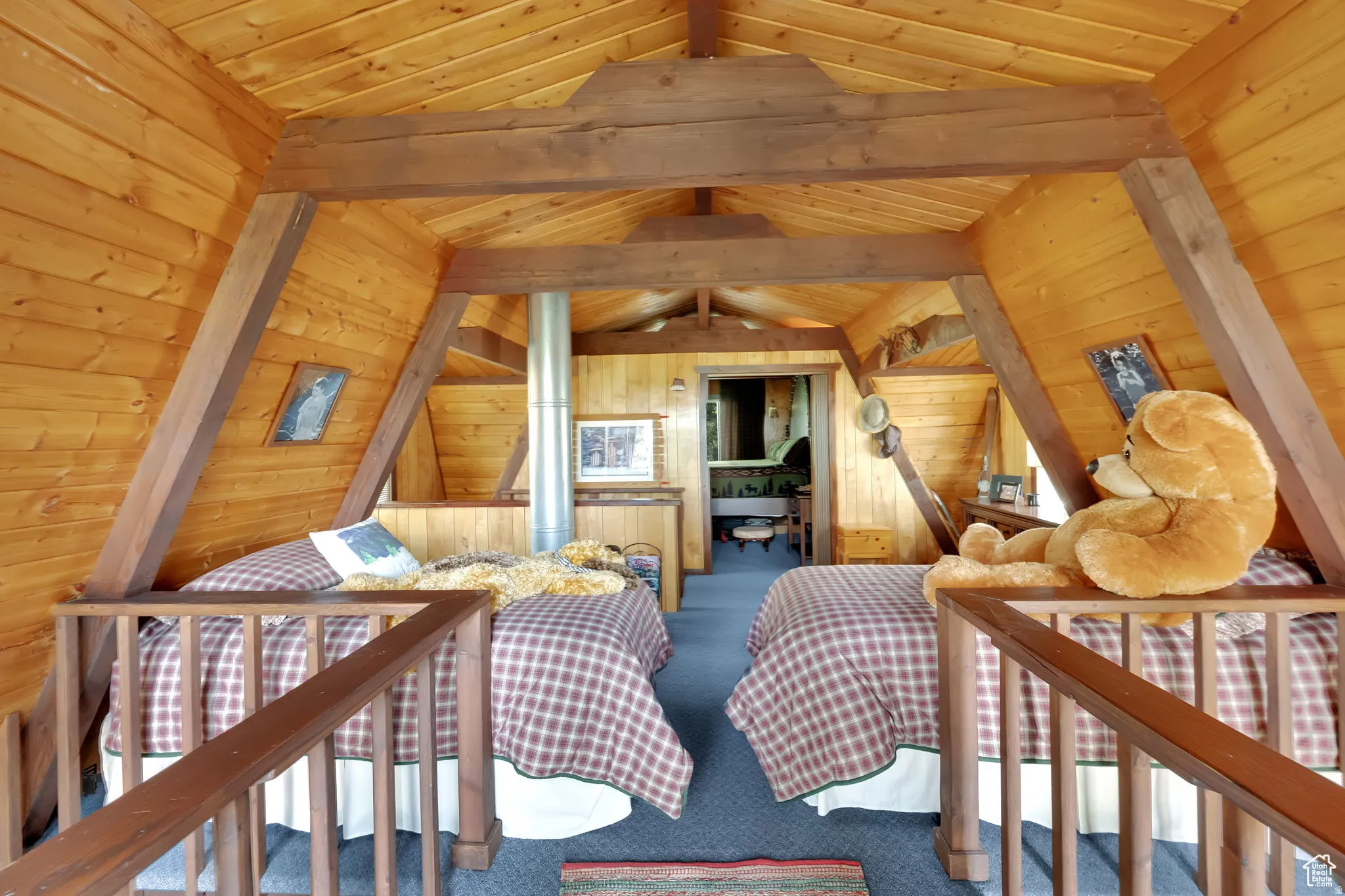 Bedroom featuring a wooden ceiling with exposed beams, wood walls, carpet flooring, and ceiling fan