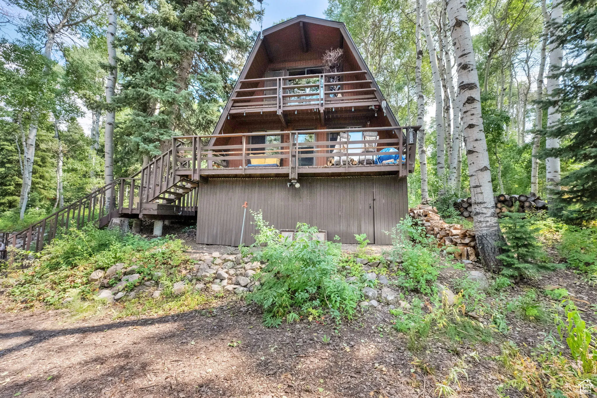 Back of property with a wooden deck and stairway