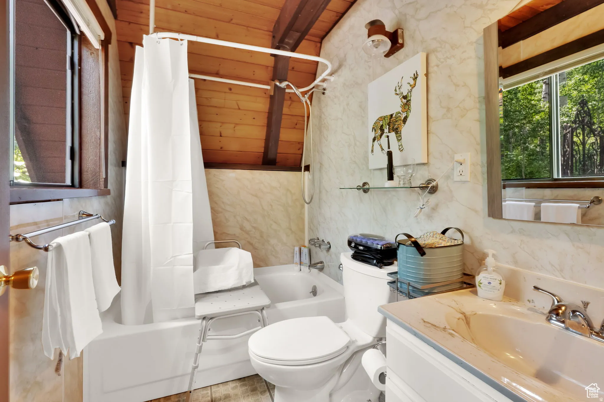 Bathroom with plenty of natural light, shower / tub combo with curtain, vanity, and wooden ceiling