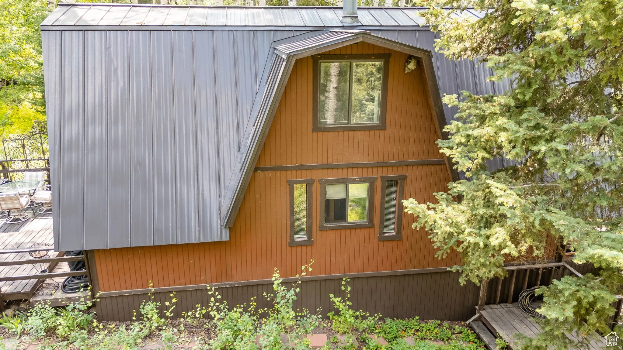 View of side of property with a metal roof and a gambrel roof