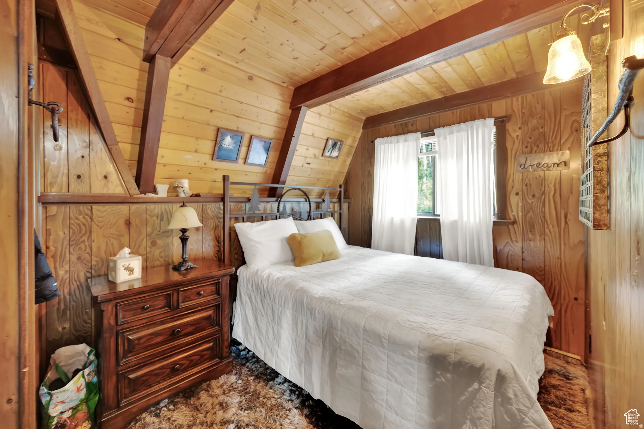 Bedroom featuring wood walls and a wooden ceiling with exposed beams