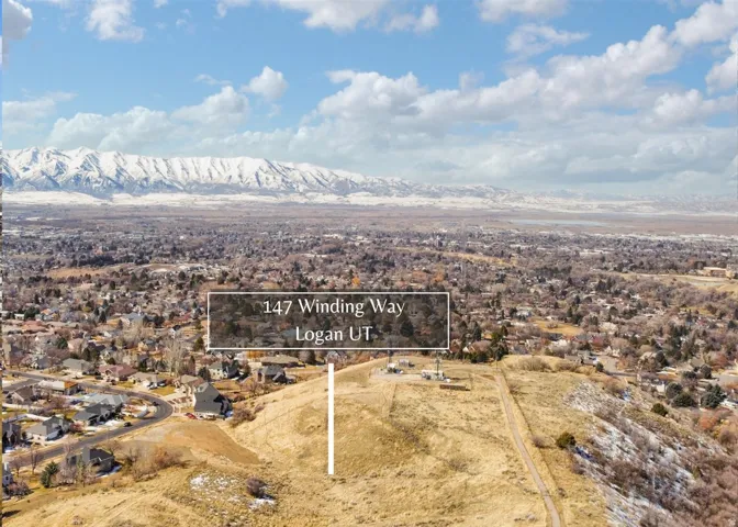Aerial view of residential area featuring property boundaries highlighted and a mountainous background