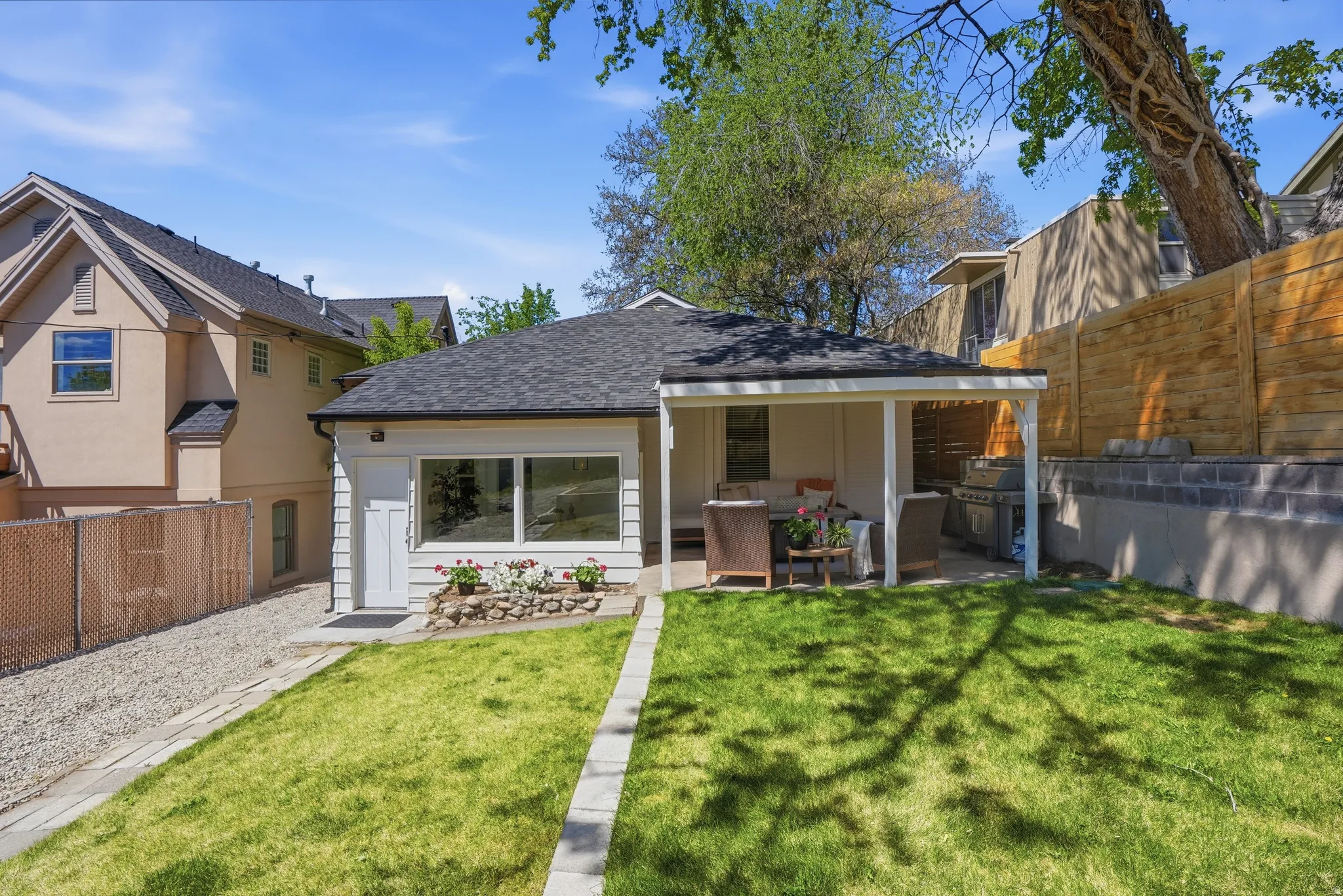 Back of house featuring a fenced backyard, a shingled roof, and a patio area