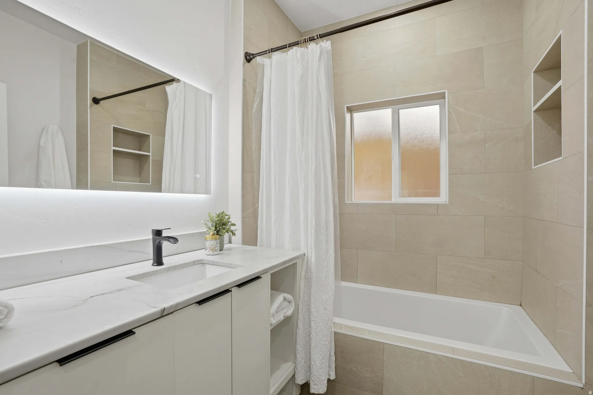 Full bath with vanity and tiled shower / bath combo with marble countertops
