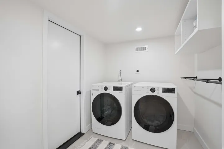 Laundry room featuring washing machine and clothes dryer and recessed lighting
