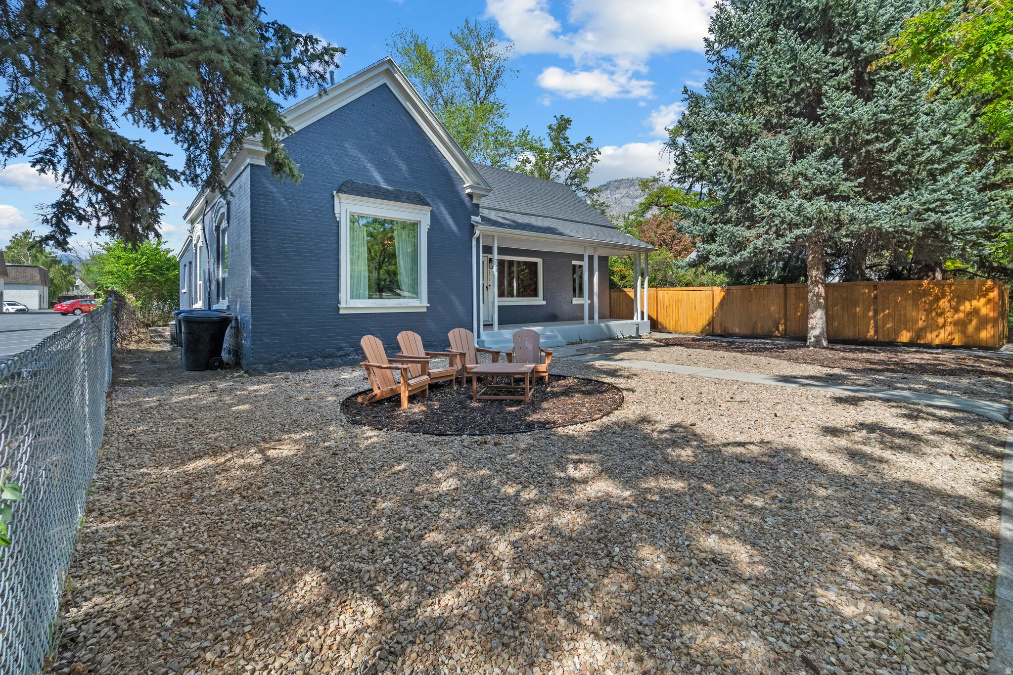 Rear view of property featuring a fenced backyard, brick siding, an outdoor fire pit, and a patio area