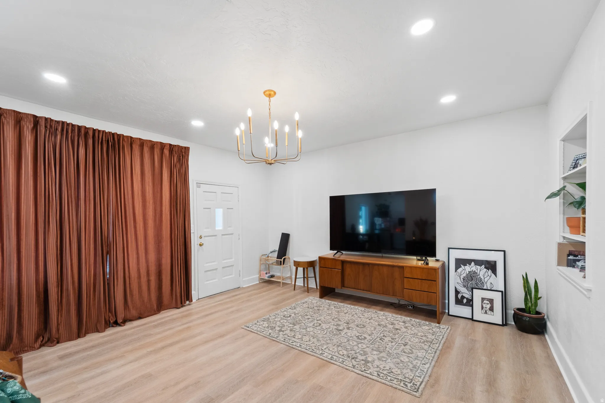 Living room featuring light wood finished floors and a chandelier