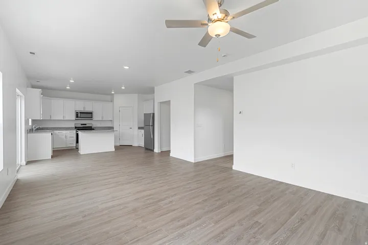 Unfurnished living room featuring light wood-style floors, ceiling fan, and recessed lighting