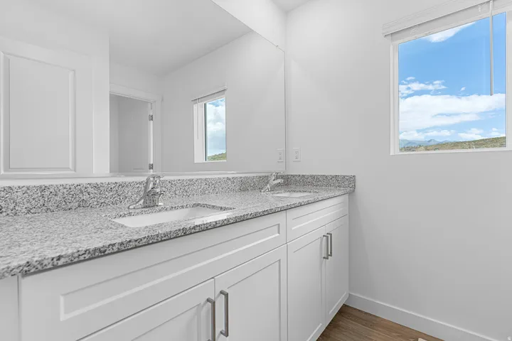 Bathroom with double vanity and dark wood finished floors