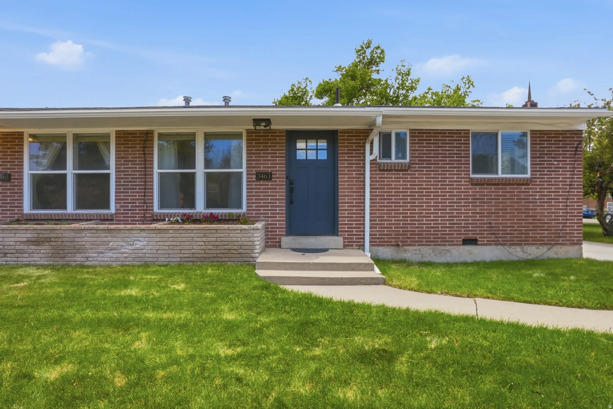 Ranch-style home featuring brick siding, a front lawn, and entry steps