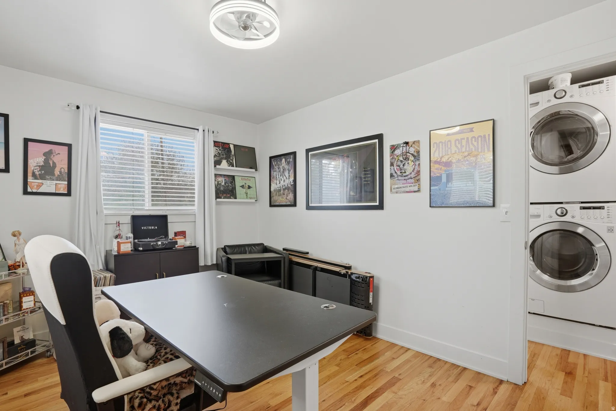 Office space featuring light wood-style flooring and stacked washer and dryer