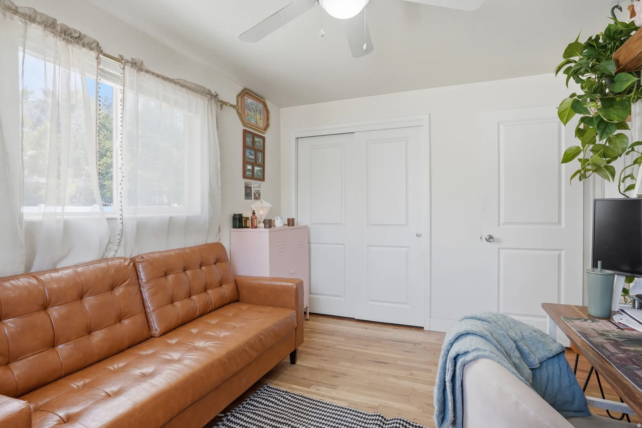 Living room with light wood-type flooring and ceiling fan