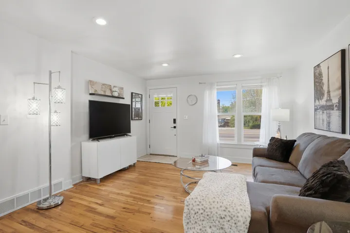 Living area featuring light wood finished floors and recessed lighting