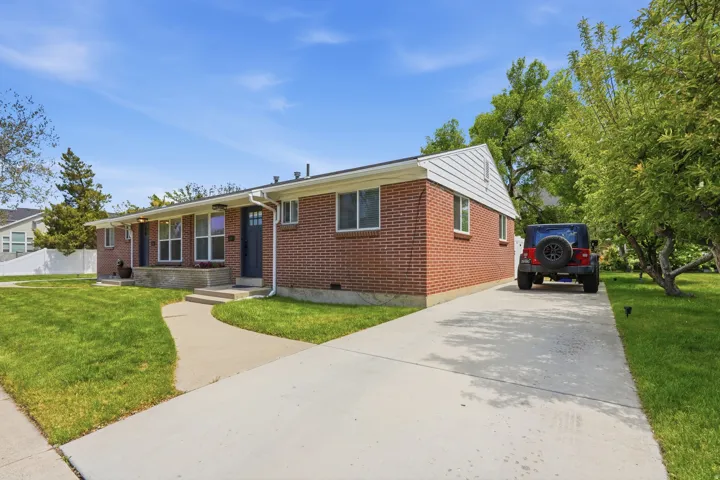 Ranch-style house featuring a front lawn, brick siding, and driveway