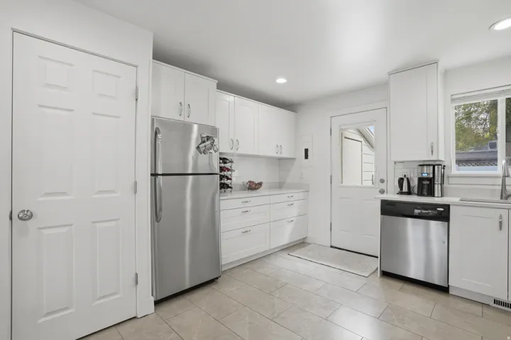 Kitchen with white cabinets, stainless steel appliances, backsplash, and recessed lighting