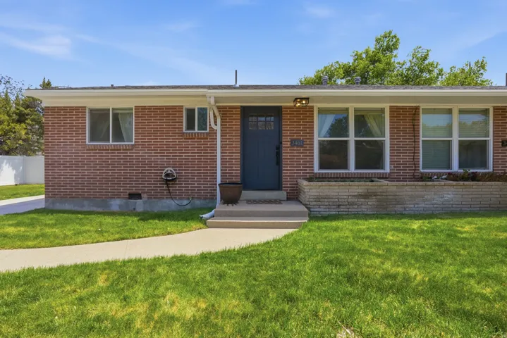 Single story home with brick siding and a front lawn