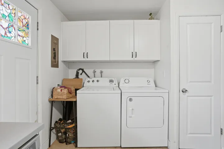 Laundry area with cabinet space, washer and dryer, and electric panel