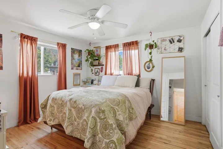 Bedroom with light wood-style floors, multiple windows, a closet, and ceiling fan