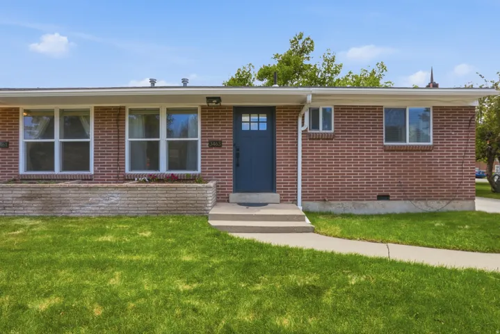Ranch-style home featuring brick siding, a front lawn, and entry steps