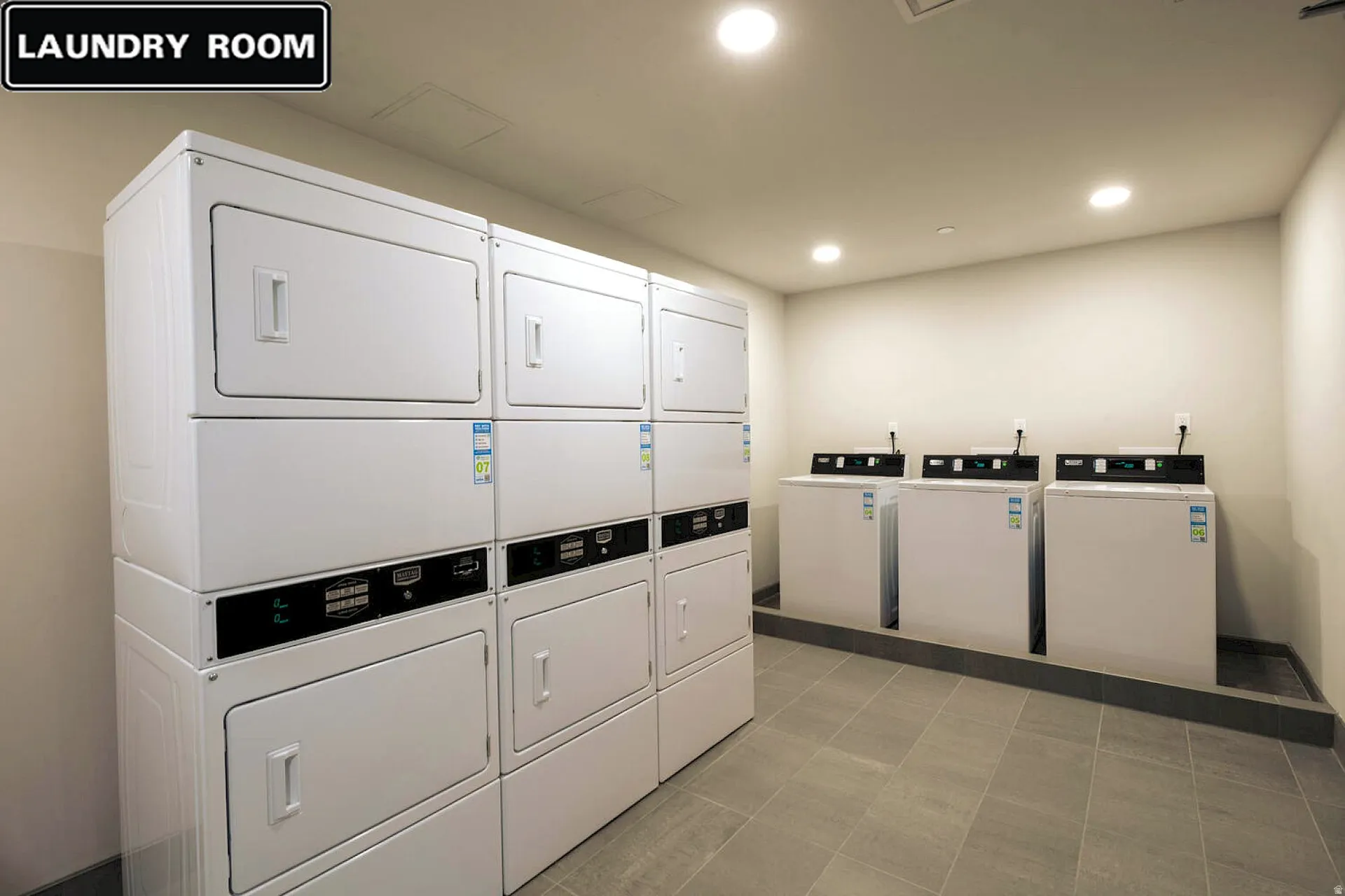 Shared laundry room with recessed lighting and stacked washer / drying machine