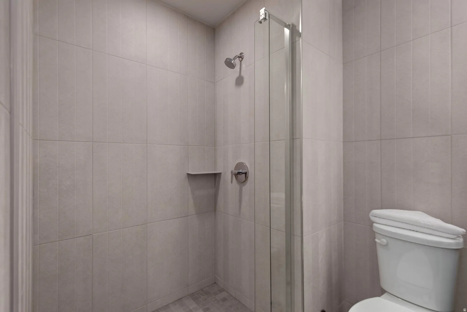 Bathroom featuring a shower stall and toilet