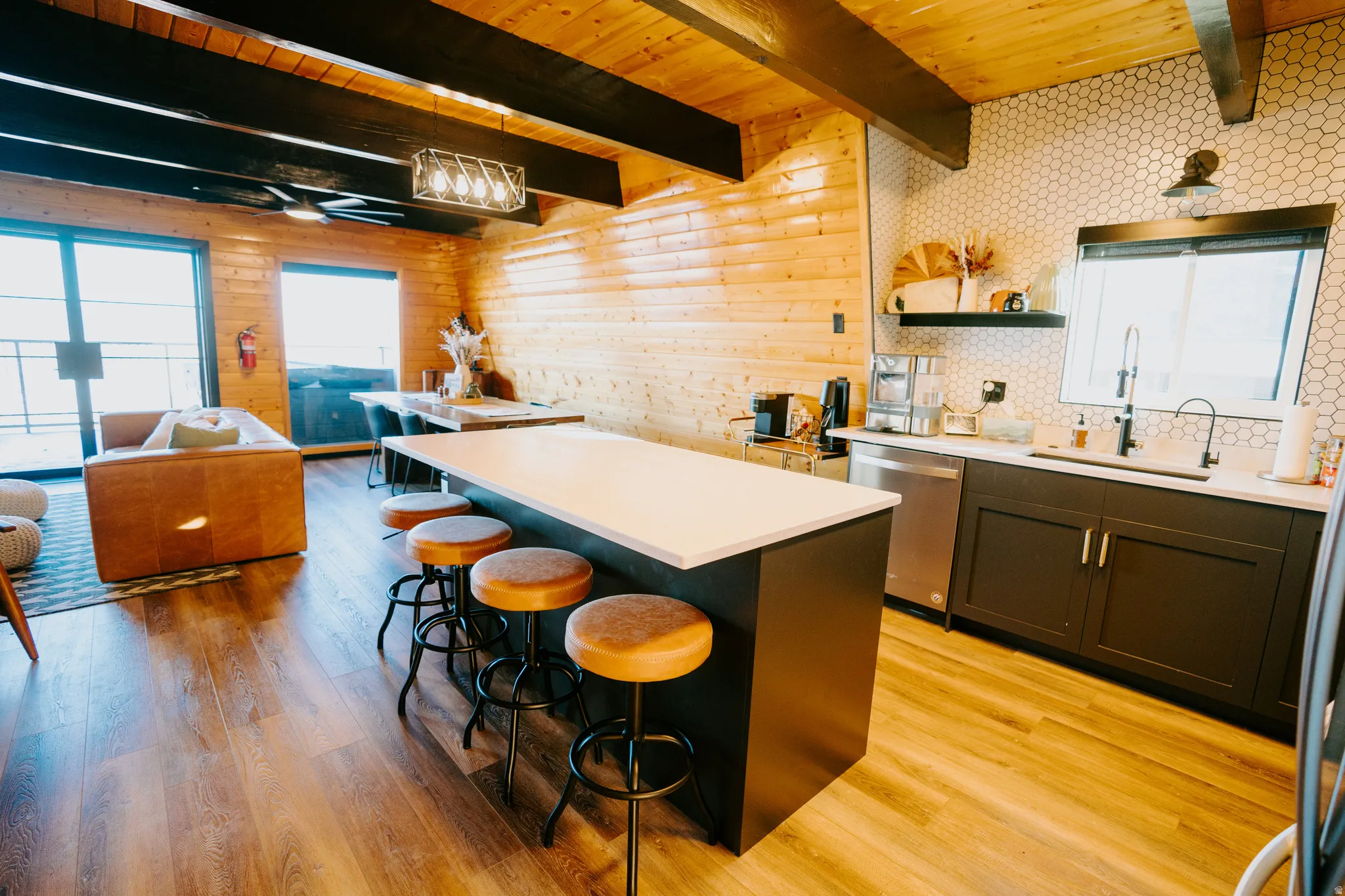 Kitchen featuring healthy amount of natural light, a wood ceiling with exposed beams, a center island, light wood-type flooring, and open floor plan