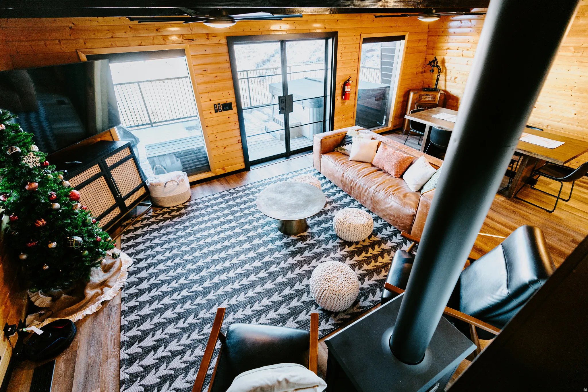 Living area with wood walls, wood finished floors, and a wood stove