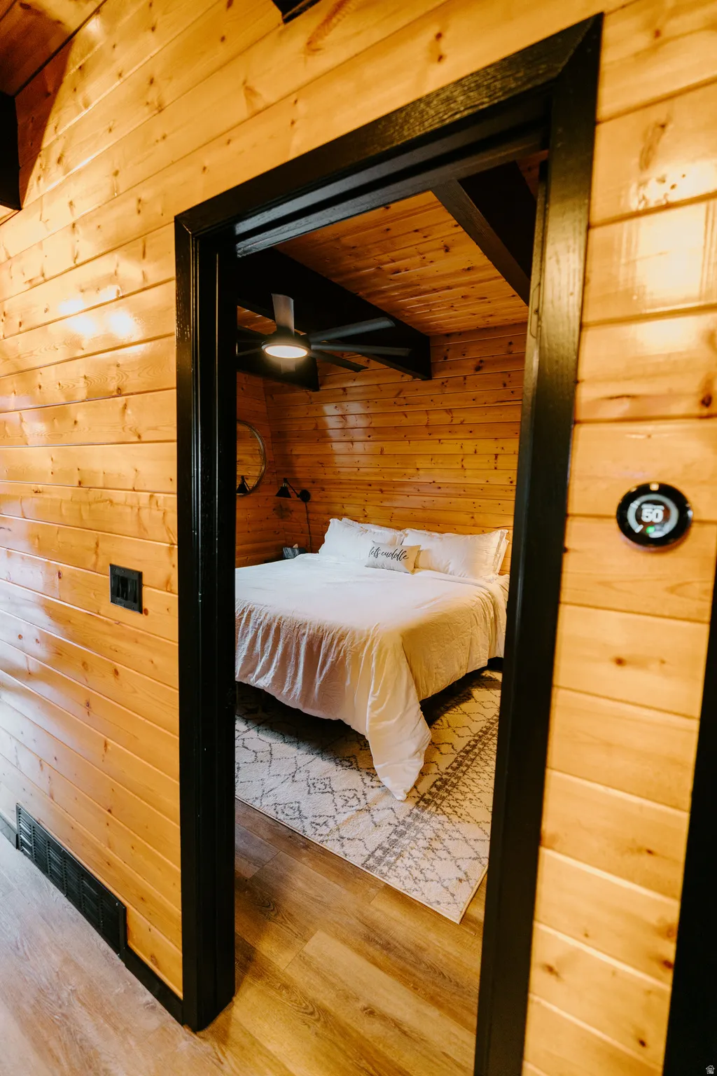Bedroom featuring wooden walls and wood finished floors