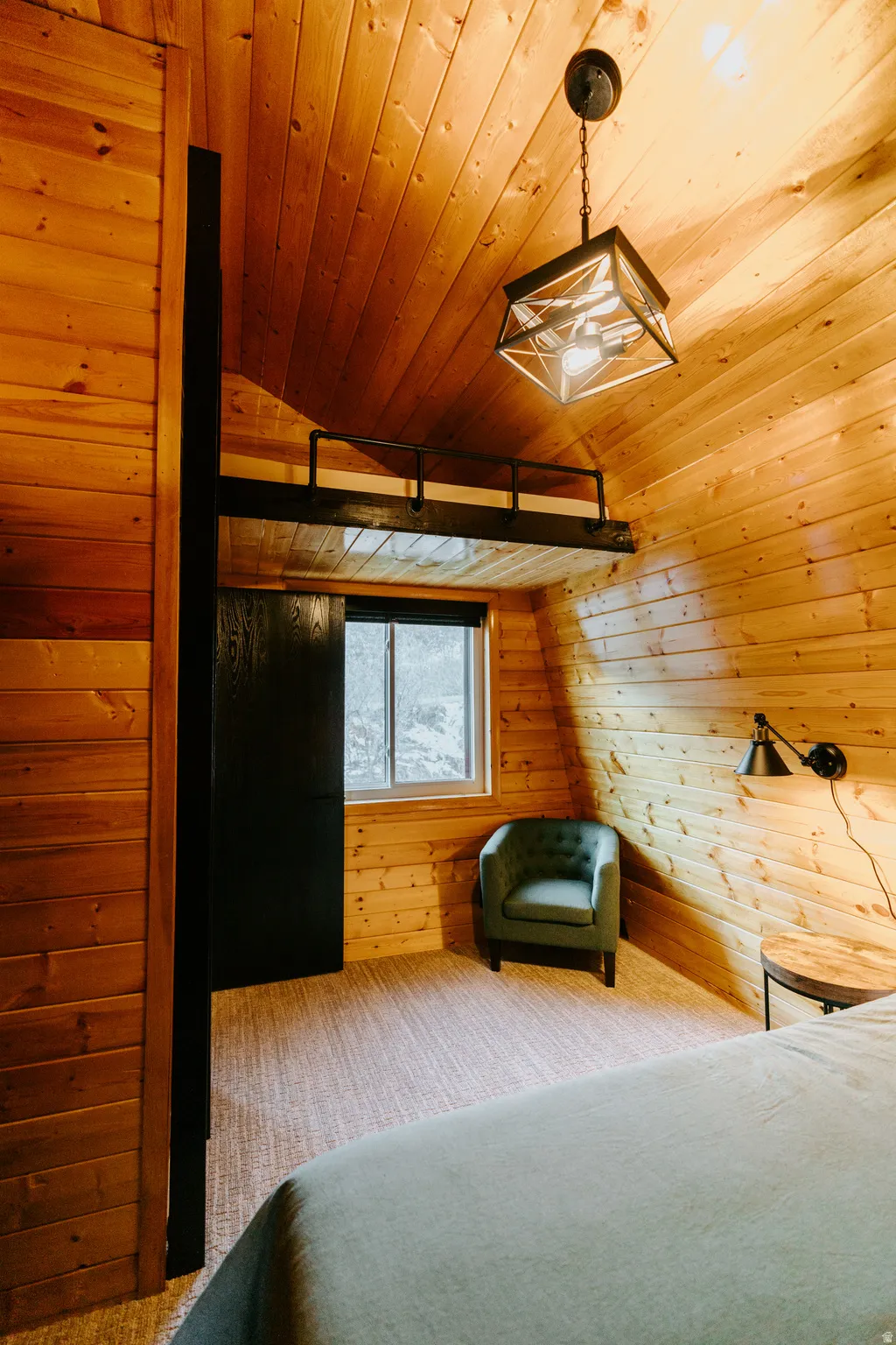 Carpeted bedroom with wood walls and a vaulted wood ceiling