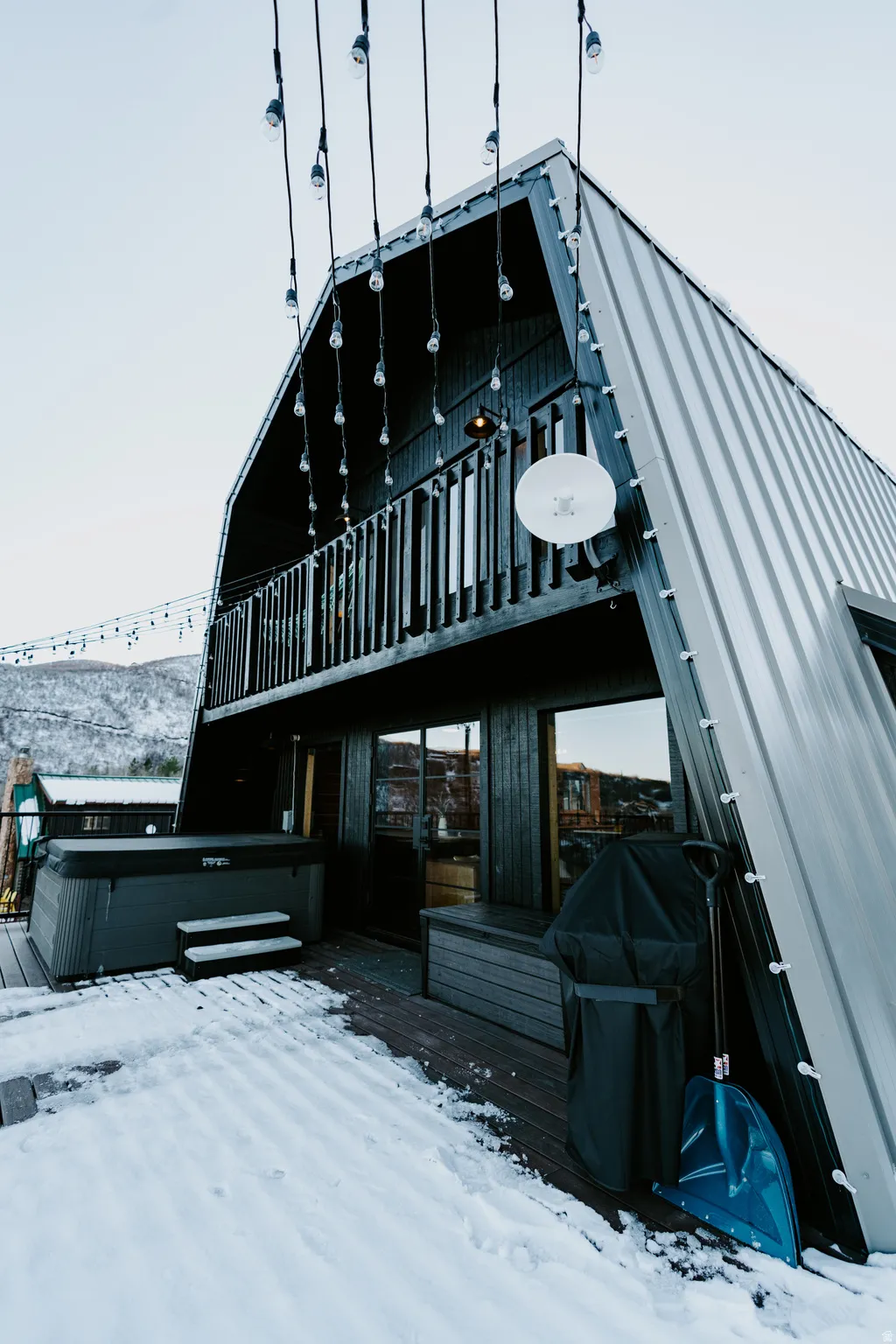 Snow covered house with a gambrel roof and a metal roof
