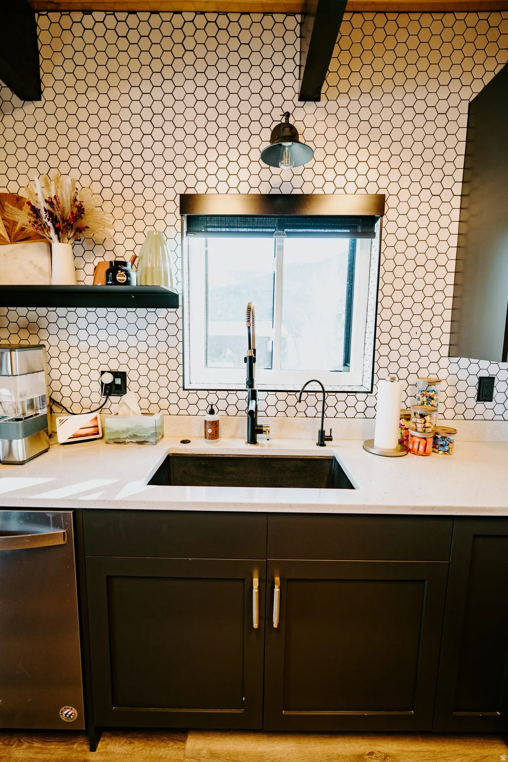 Bar area with light stone countertops, stainless steel dishwasher, beamed ceiling, and open shelves